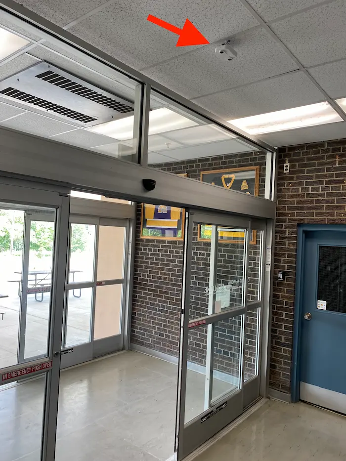 Indoor ceiling-mounted people counter above a facility doorway — 3D stereoscopic counting sensor for accurate visitor detection